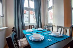 a dining room table with a blue table cloth and glasses at Pokoje w Centrum Sopotu in Sopot