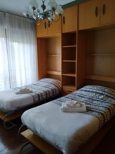 2 Einzelbetten in einem Zimmer mit Kronleuchter in der Unterkunft Apartamento Trapagaran in Trapagaran