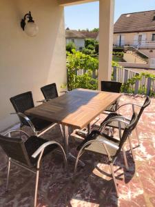 einen Holztisch und Stühle auf einer Terrasse in der Unterkunft Maison d'une chambre avec jardin amenage et wifi a Saint Julien in Saint-Julien