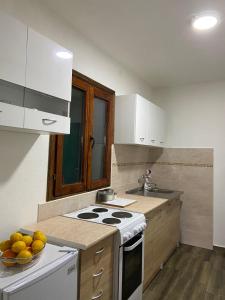 a kitchen with a stove and a bowl of fruit at Guest House Markovic Lovcen in Cetinje