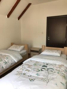 a bedroom with two beds and a black door at Guest House Markovic Lovcen in Cetinje
