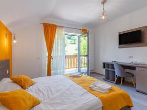 a bedroom with a large bed with a desk and a window at HAPPY TIMES in Bran +38 photos