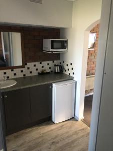 a kitchen with a white refrigerator and a sink at Creswick Motel in Creswick