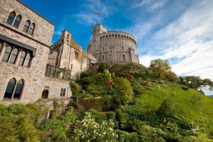 um castelo no topo de uma colina com flores em Castle Hotel Windsor em Windsor