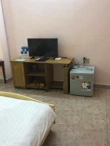 a desk with a computer and a bed in a room at Khách sạn Cà Ná in Phan Rang