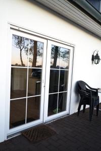 a patio with sliding glass doors and a black chair at Monteurwohnung Oyten bei Bremen A1 dat Landhuus in Oyten +14 photos