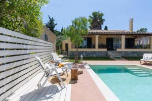 a villa with a swimming pool and a house at Villa Caramel in Agios Ioannis