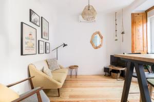 ein Wohnzimmer mit einem Stuhl und einem Tisch in der Unterkunft Feel Home in this Stunning Renovated Nest in Graça in Lissabon