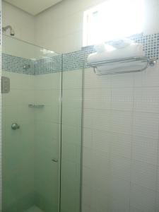a glass shower in a bathroom with a glass door at Corumbá Plaza Hotel in Luziânia +43 photos