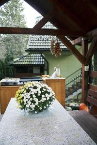 a table with a vase of flowers on it at Apartma Pegaz in Rogaška Slatina