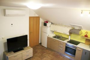 a small kitchen with a sink and a tv at Apartma Pegaz in Rogaška Slatina