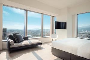 a bedroom with a bed and a tv and large windows at amba Taipei Songshan in Taipei