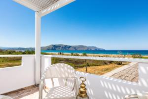 balkon z krzesłem i widokiem na ocean w obiekcie Pinelopi Beach Suites w mieście Georgioupolis