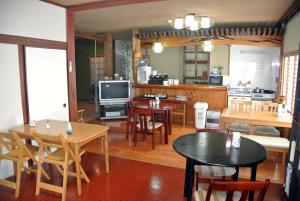 Takachiho B&B Ukigumo في تاكاتشيهو: مطبخ وغرفة طعام مع طاولات وكراسي
