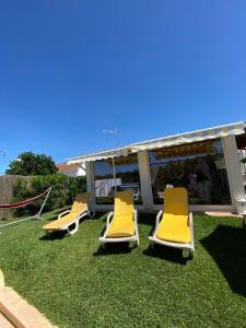 een groep gele stoelen op het gras bij Quintinha do Zé da Lola in Silveiras