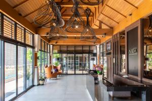 an open lobby with windows and chairs and chandeliers at Mida Hotel Don Mueang Airport in Bangkok