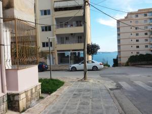 a white car parked in front of a building at Alexandra Apartament in Sarandë