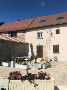 a house with a courtyard with flowers in front of it at L’Ecrin champenois : 150m2 au cœur du vignoble in Étoges