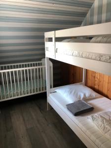 two bunk beds are in a room with a wooden floor at L’Ecrin champenois : 150m2 au cœur du vignoble in Étoges