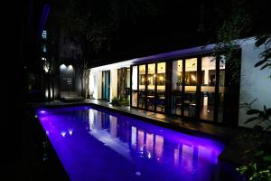 a swimming pool at night with purple lights at BED Phrasingh-Adults Only in Chiang Mai