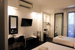 a hotel room with a bed and a desk and a mirror at BED Phrasingh-Adults Only in Chiang Mai