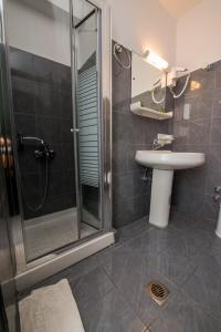 a bathroom with a glass shower and a sink at Sandy Beach Villas and Apartments in Svoronata