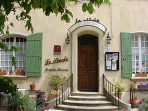 - un bâtiment avec une porte en bois et des escaliers à l'avant dans l'établissement Hôtel Le Siècle, à Mazan