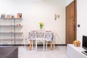 Centro Storico Oltretorrente Apartment في بارما: طاولة طعام وكراسي في الغرفة