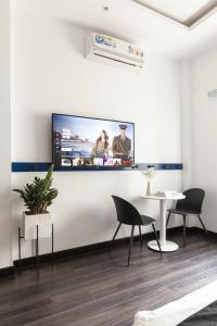 a living room with a tv on a white wall at Central Studios at Ben Thanh Market by CIRCADIAN in Ho Chi Minh City