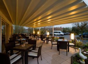ein Restaurant mit Tischen und Stühlen unter einem großen Sonnenschirm in der Unterkunft Hotel Blankenfeld in Wetzlar