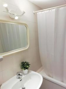 uma casa de banho branca com um lavatório e um espelho em Trill Mirasol B estudio 1a linea mar em L'Estartit