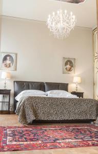 ein Schlafzimmer mit einem großen Bett und einem Kronleuchter in der Unterkunft Rialto Canal View With Terrace and Balcony by Wonderful Italy in Venedig