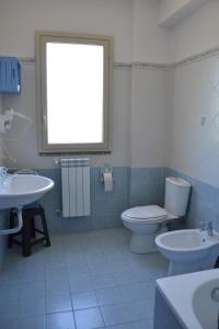 ジャルディーニ・ナクソスにあるB&B fragranza di siciliaのバスルーム(洗面台2台、トイレ付)、窓が備わります。