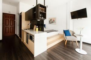 a small room with a bed and a kitchen at Central Studios at Ben Thanh Market by CIRCADIAN in Ho Chi Minh City