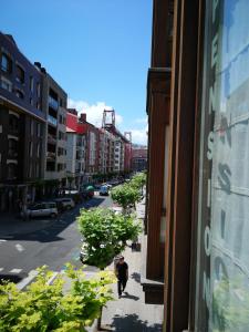 un hombre caminando por una calle de la ciudad desde una ventana en Pension Areeta, en Getxo