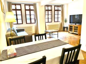 a living room with a table and a couch and a television at Apartmány Nerudova 36 in Prague