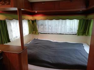 1 dormitorio con cama con dosel frente a una ventana en Caravan en Samtens