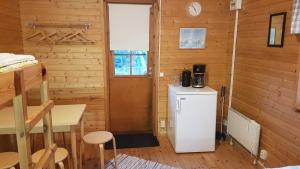 eine kleine Küche mit Kühlschrank und Tisch in der Unterkunft Kökar Havspaviljong Cottages in Kökar + 16 Fotos