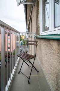 une chaise en bois assise sur le balcon d'un bâtiment dans l'établissement apartmán v bytovém domě Turnov, à Turnov