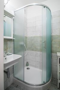 uma cabina de duche em vidro na casa de banho com um lavatório em apartmán v bytovém domě Turnov em Turnov