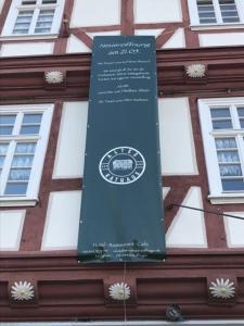 un cartello blu sul lato di un edificio di Altes Rathaus Hotel-Restaurant-Café a Wolfhagen