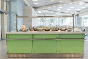 a green buffet with bowls of food on it at HI - Haifa Hostel in Haifa