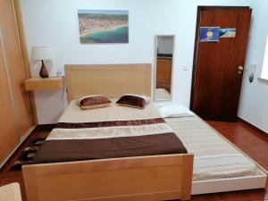 um quarto com uma cama grande num quarto em Estúdio - Nazaré na Nazaré