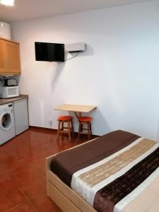 ナザレにあるEstúdio - Nazaréのベッドルーム1室(ベッド1台、テーブル、椅子2脚付)