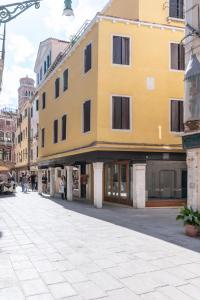 um edifício amarelo no lado de uma rua em Grifoni Boutique Hotel em Veneza