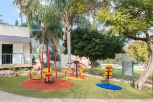 a playground with colorful play equipment in a park at HI - Maayan Harod Hostel in Gid‘ona