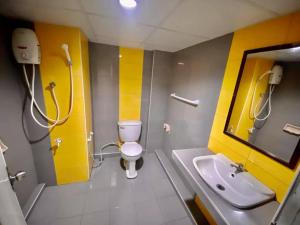 ein Badezimmer mit einem WC, einem Waschbecken und einem Spiegel in der Unterkunft Pasawang Hotel (โรงแรมภาสว่าง) in Hat Yai