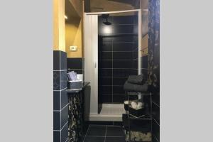 a bathroom with black tiles and a shower at meravigghia sicily home in Agrigento