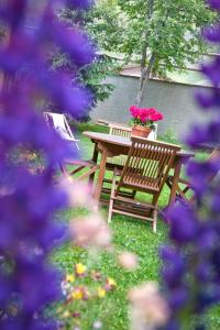 a wooden bench with a table with flowers on it at Chalet la Lauzette in Bessans