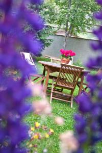 eine Holzbank mit einem Tisch mit Blumen darauf in der Unterkunft Chalet la Lauzette in Bessans